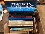 une boîte remplie de livres posée sur une table, avec un ordinateur portable à l'arrière-plan