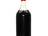 a bottle of black liquid sitting on a white surface