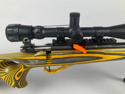a close up of a rifle with a rifle scope on top of it