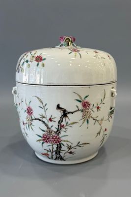un récipient blanc orné d'un oiseau et de fleurs