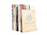 several books are stacked on top of each other on a white surface