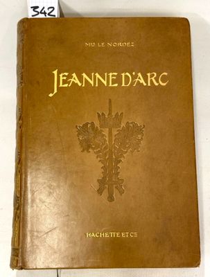an old book with gold lettering on it sitting on a white surface
