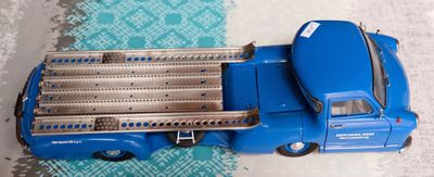 un petit camion bleu en plastique posé sur une table