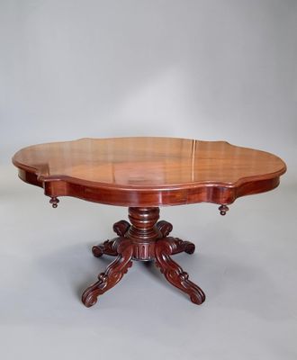 une table à manger ovale en acajou avec deux rallonges sur le plateau