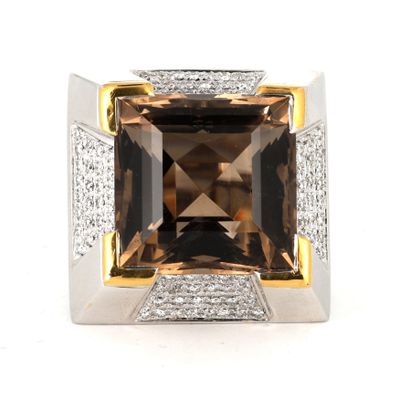 a close up of a ring with a brown stone surrounded by diamonds