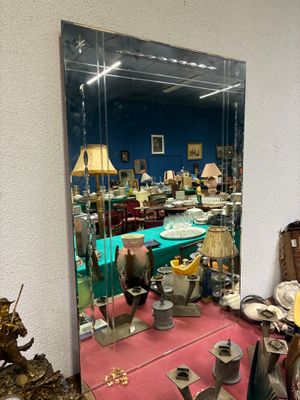 un grand miroir au milieu d'une pièce remplie d'antiquités