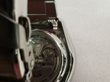 a close up of a watch on a white surface