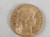 a close up of a gold coin with a woman ' s head on it