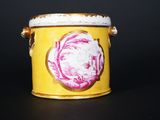 a yellow container with a pink flower on it