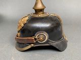 an old helmet with a golden decoration on the top of it