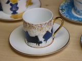 three cups and saucers on a table with a blue and yellow design