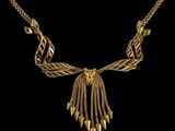 un collier plaqué or orné de pointes et de chaînes sur fond noir