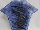 un vase bleu orné de lignes noires sur fond blanc