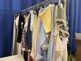 de nombreux vêtements suspendus à un portant dans une pièce