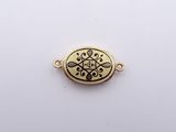 a close up of a gold plated pendant on a white surface