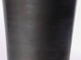 a black vase sitting on a table with a white background