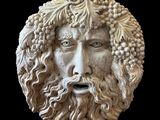 statue d'un homme barbu, avec une barbe de raisins sur la tête