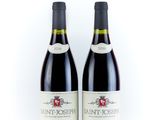 two bottles of wine sitting next to each other on a white surface