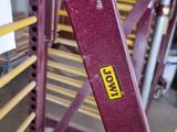 a red metal ladder with a yellow sticker on it