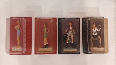 three plastic figurines of women in different outfits are displayed on a white surface