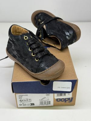 une boîte sur laquelle est posée une paire de chaussures noires