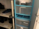 a closet with several drawers and a shelf with clothes