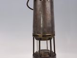 an old fashioned metal lantern with a light on top of it