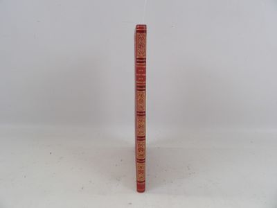 un livre rouge posé sur une table blanche