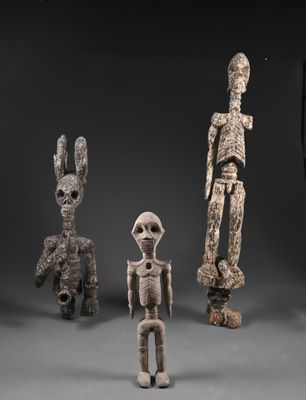 un ensemble de trois figurines en bois sculpté représentant un homme, une femme et un enfant