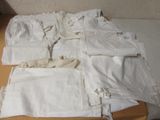 a lot of white cloths on a table next to each other