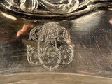 an antique silver plate with a monogram on it