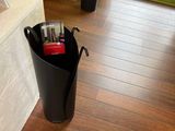 a black trash can sitting on the floor next to a window