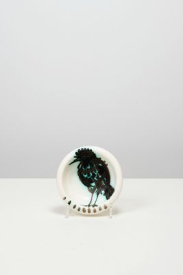 un oiseau noir perché sur une assiette blanche