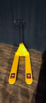 un chariot élévateur jaune posé sur un plancher en bois