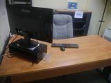 un bureau sur lequel se trouvent un écran, un clavier, une souris et d'autres éléments