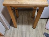 une petite table avec un plateau en bois, dans un coin de la pièce
