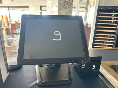 un écran d'ordinateur posé sur une table sur laquelle se trouve une horloge