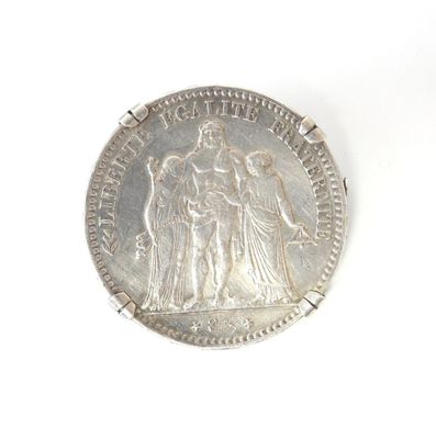 an old silver coin with an image of a woman and two men on it