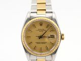 une photo d'une montre Rolex dorée et argentée posée sur une surface blanche