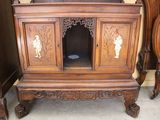 a wooden cabinet with carvings on it in a room