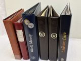 quatre livres sont alignés sur une surface blanche