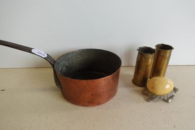 une petite casserole en métal et une petite tasse en métal posées sur une table
