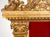 a gold frame with a red curtain in the corner