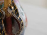 a vase that has a handle on it on a table