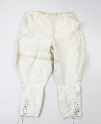 un vieux pantalon blanc accroché à un mur blanc