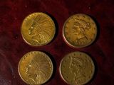 three gold coins sitting on top of a brown leather surface