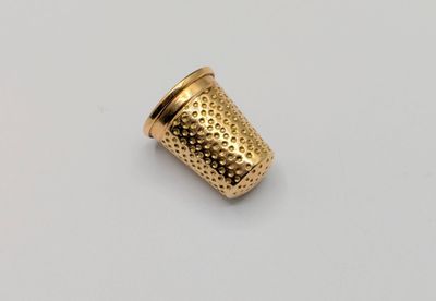 a close up of a gold cup on a white surface