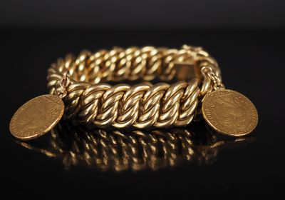 un gros plan d'un bracelet en or orné de deux pièces