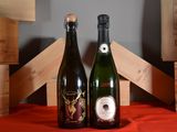 two bottles of wine sitting next to each other on a table