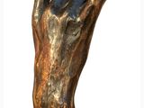 statue of a hand with a raised finger on a wooden base